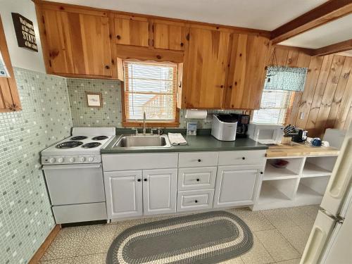a kitchen with a white stove and a sink at SUNSET SHORES LIMIT 4 cottage in Gray