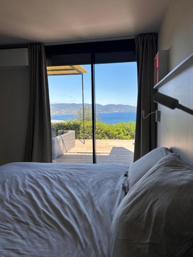 une chambre avec un lit et une vue sur l'océan dans l'établissement maison gaou bénat vue à 180°, à Bormes-les-Mimosas