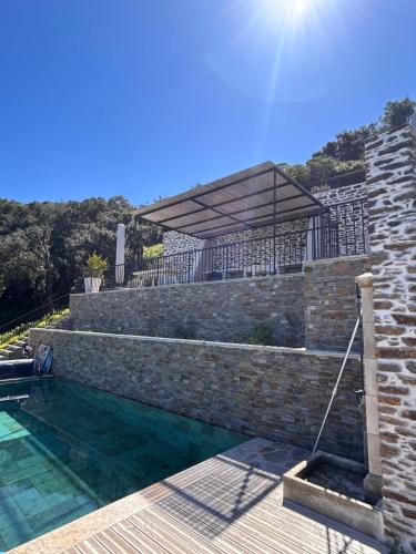 - une piscine à côté d'un mur de briques dans l'établissement maison gaou bénat vue à 180°, à Bormes-les-Mimosas