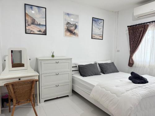 a bedroom with a bed and a dresser and a mirror at Kids-Dee Home in Sathani Padang Besa
