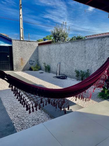 a hammock in a courtyard with a wall at Chale aconchegante da ilha in Florianópolis