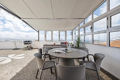 a dining room with a table and chairs and windows at Funchal Ocean Terrace APT in Funchal