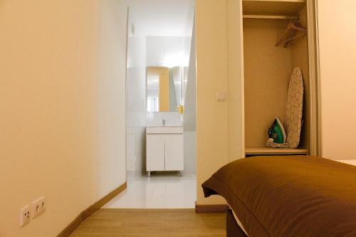 Un dormitorio con una cama y un baño con lavabo. en Rampa 24, en Vila Real