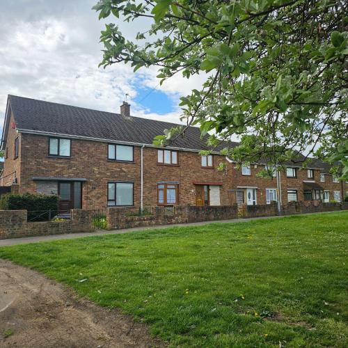 a large brick house with a green lawn in front of it at Peace and Love House in Kent