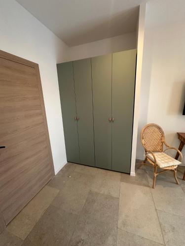 a room with green cabinets and a chair and a door at 27 côté remparts in Aigues-Mortes