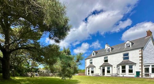 a large white house with a tree in the foreground at St George's Hotel in Perranporth