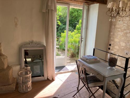 une salle à manger avec une table et une porte menant à une terrasse dans l'établissement maison bohème, à Rou-Marson