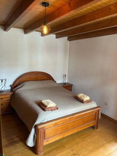 a bedroom with a wooden bed with two pillows on it at Casa da Cantarinha in Fundão