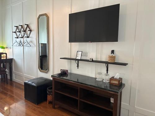 a living room with a television on a wall at Baan Debtida in Bangkok