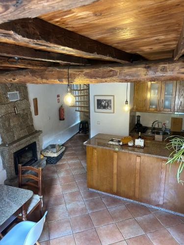 a kitchen with wooden cabinets and a fireplace at Casa da Cantarinha in Fundão