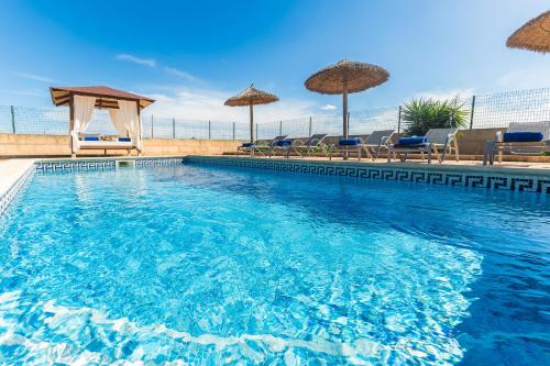 a large swimming pool with chairs and umbrellas at Son Sea Villa in Campos