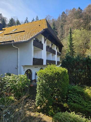 a white house with a roof with a balcony at Triberg Falls Hideaway - Apartment 35 in Triberg