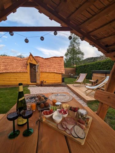 - une table avec un plateau de nourriture et une bouteille de vin dans l'établissement Cabane Insolite Cosy, à Ramonchamp