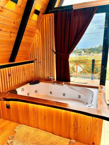 a bath tub in a room with a window at Mirana Bungalov in Ardeşen