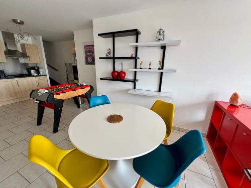 une salle à manger avec une table et des chaises blanches dans l'établissement La Terrasse vue étangs, Babyfoot, jeux de société by BookingFuté, à Socourt