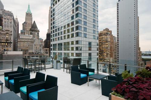 eine Dachterrasse mit Stühlen und Tischen auf einem Gebäude in der Unterkunft Club Quarters Hotel World Trade Center, New York in New York