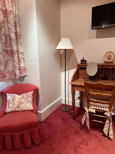 a living room with a piano and a red couch at Chalet La Forestière in Saint-Paul-en-Chablais