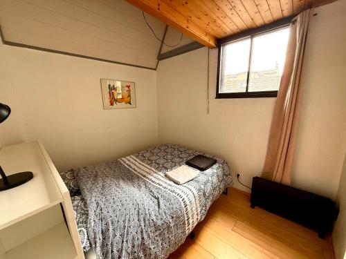une petite chambre avec un lit et une fenêtre dans l'établissement Chaleureux appartement centre ville proche gare., à Besançon
