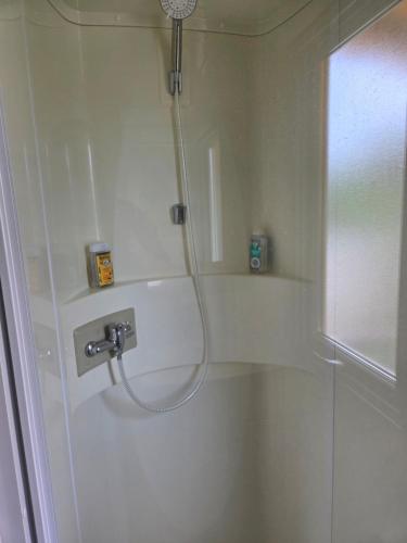 a shower with a hose in a bathroom at Fabuleux mobil-homme 4/6 personnes in Fréjus