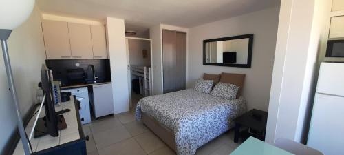 Cette petite chambre comprend un lit et une télévision. dans l'établissement Studio 419, Port Vénus au village naturiste, au Cap d'Agde