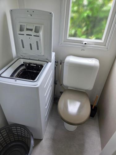 a small bathroom with a toilet and a window at Fabuleux mobil-homme 4/6 personnes in Fréjus