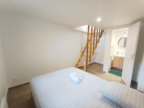 - un lit blanc dans une chambre avec un escalier dans l'établissement Charming duplex, à Vitry-sur-Seine