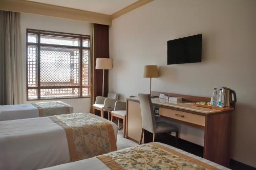 a hotel room with a desk and a television at Le Bosphorus Hotel Two in Al Madinah