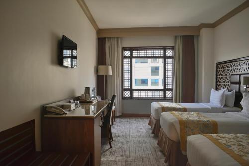 a hotel room with two beds and a window at Le Bosphorus Hotel Two in Al Madinah