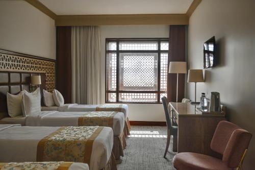 a hotel room with two beds and a window at Le Bosphorus Hotel Two in Al Madinah