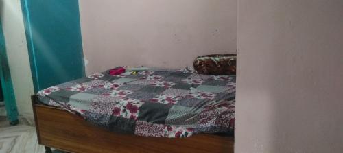 a bedroom with a bed with a quilt on it at Aruntyagi in Khekra