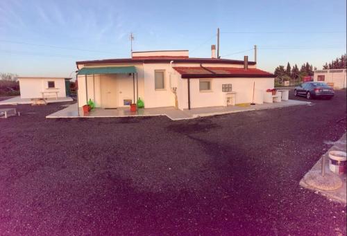 a house with a car parked in a parking lot at Case Vacanze - da Francesco in Policoro