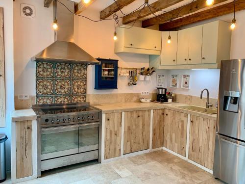 - une cuisine avec des placards en bois et une cuisinière dans l'établissement L'Orée rouge de la Forêt, à Villefranche-Sur-Cher