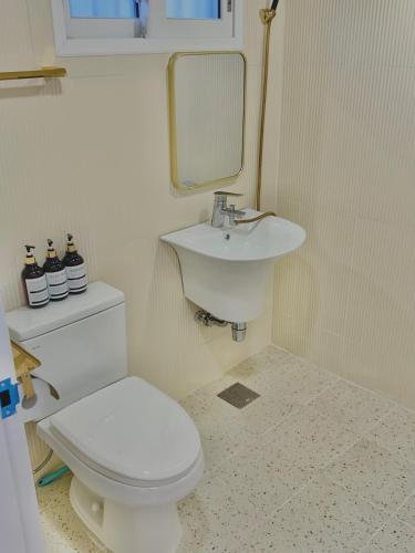 a bathroom with a white toilet and a sink at Momo House in Gimhae