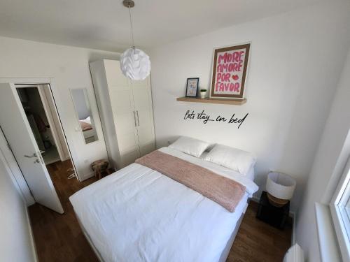 a bedroom with a bed and a sign on the wall at Apartment Endorfin - Modern apartment close to airport in Surčin