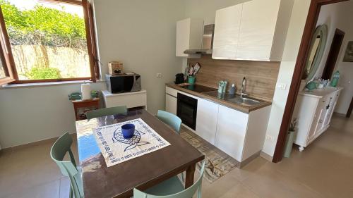 a kitchen with a table and a kitchen with a sink at Villa Ingrosso in Leporano Marina