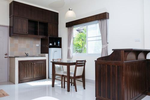 a kitchen with wooden cabinets and a table and chairs at Villa Wanida Garden Resort in North Pattaya