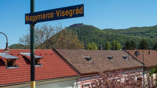 a street sign in front of houses with a mountain at Nagymaros Apartman in Nagymaros