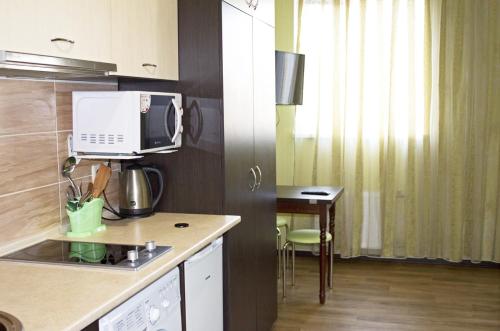 a kitchen with a microwave and a table in it at Studio in the city center metro Historical Museum in Kharkiv