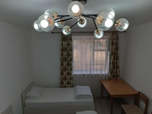 a room with a bed and a window with a chandelier at Marsad in Kazarman