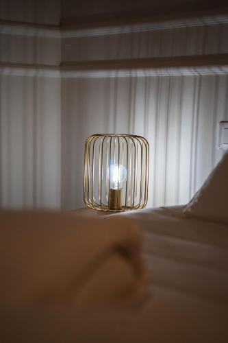a lamp sitting on the side of a bed at Locanda Gaudemus Boutique Hotel in Sistiana