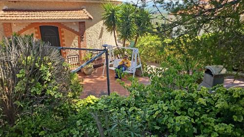 a person sitting on a swing in a garden at Villa Paola appartamento completo in Ciminna