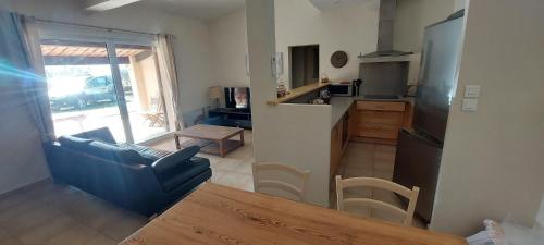 un salon avec un canapé bleu et une cuisine dans l'établissement La Ventourette, à Le Barroux