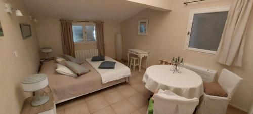 une chambre avec deux lits et une table et une fenêtre dans l'établissement La Ventourette, à Le Barroux