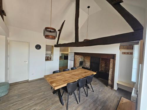 une grande salle à manger avec une table et des chaises en bois dans l'établissement Cottage Salomé, à Rue