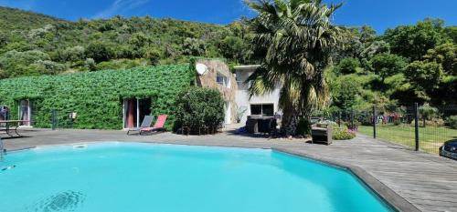 une grande piscine devant une maison dans l'établissement PRAMOUSQUIER VILLA LOFT DE CHARME 2 PISCINES interieure et exterieure, au Lavandou