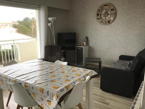 une salle à manger avec une table, des chaises et une horloge dans l'établissement Apparemment à 50 mètres de la mer, à Notre-Dame-de-Monts
