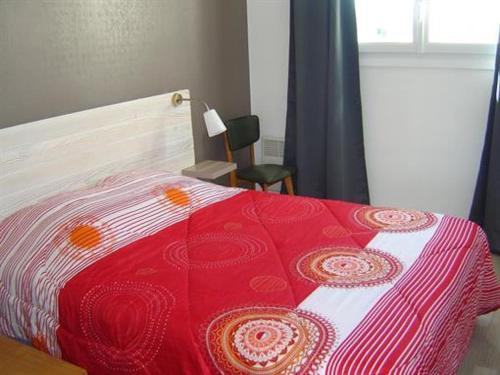 - un lit avec une couverture rouge et blanche dans l'établissement Apparemment à 50 mètres de la mer, à Notre-Dame-de-Monts