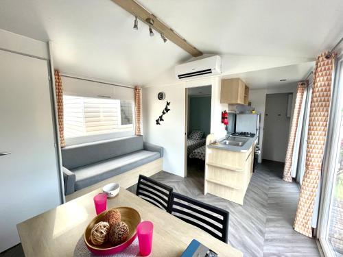 Ce petit appartement comprend une cuisine et une table à manger. dans l'établissement Séjour détente en mobil-home 4 à 6 pers Camping 4 étoiles, à Saint-Julien-en-Born