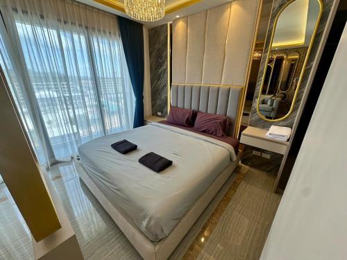 a large bed in a room with a large window at Bellevue lagoon 20 units in Laguna Phuket