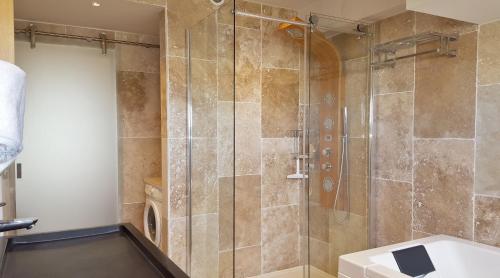 une salle de bain avec une douche avec une porte vitrée dans l'établissement Appart 385, Port Nature 3 au village naturiste, au Cap d'Agde